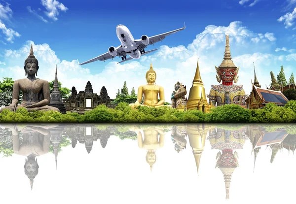 A vibrant landscape featuring various Buddha statues, ornate temples, and an airplane in the sky with a blue backdrop and clouds.